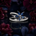 MUHUANG sapphire and diamond flower ring with white gold band on dark floral background