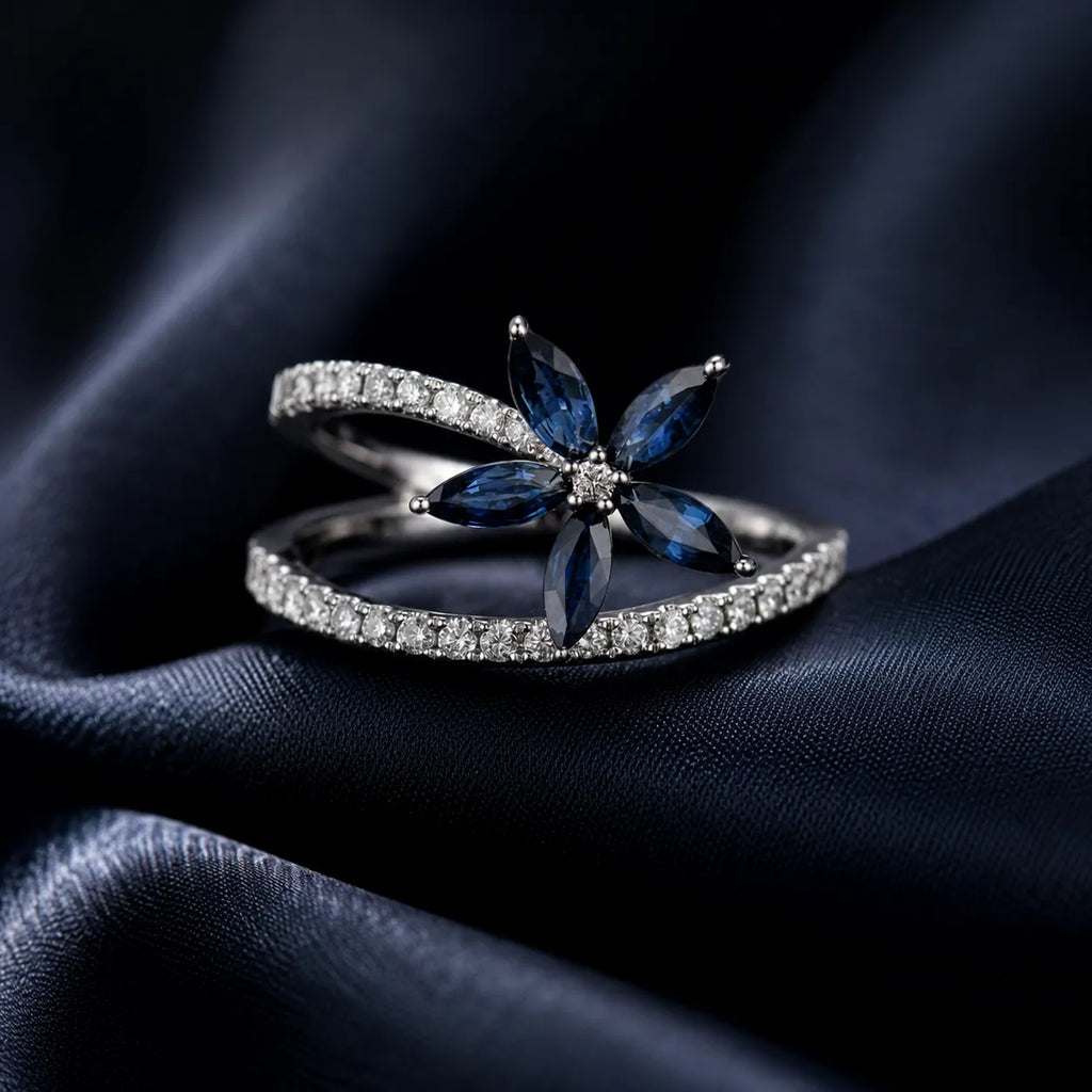 MUHUANG sapphire and diamond floral ring displayed on dark blue satin fabric