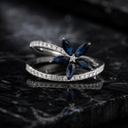 MUHUANG blue sapphire flower ring with diamond accents on black marble background