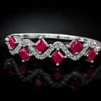 MUHUANG white gold ruby wave ring with diamond accents on black reflective surface