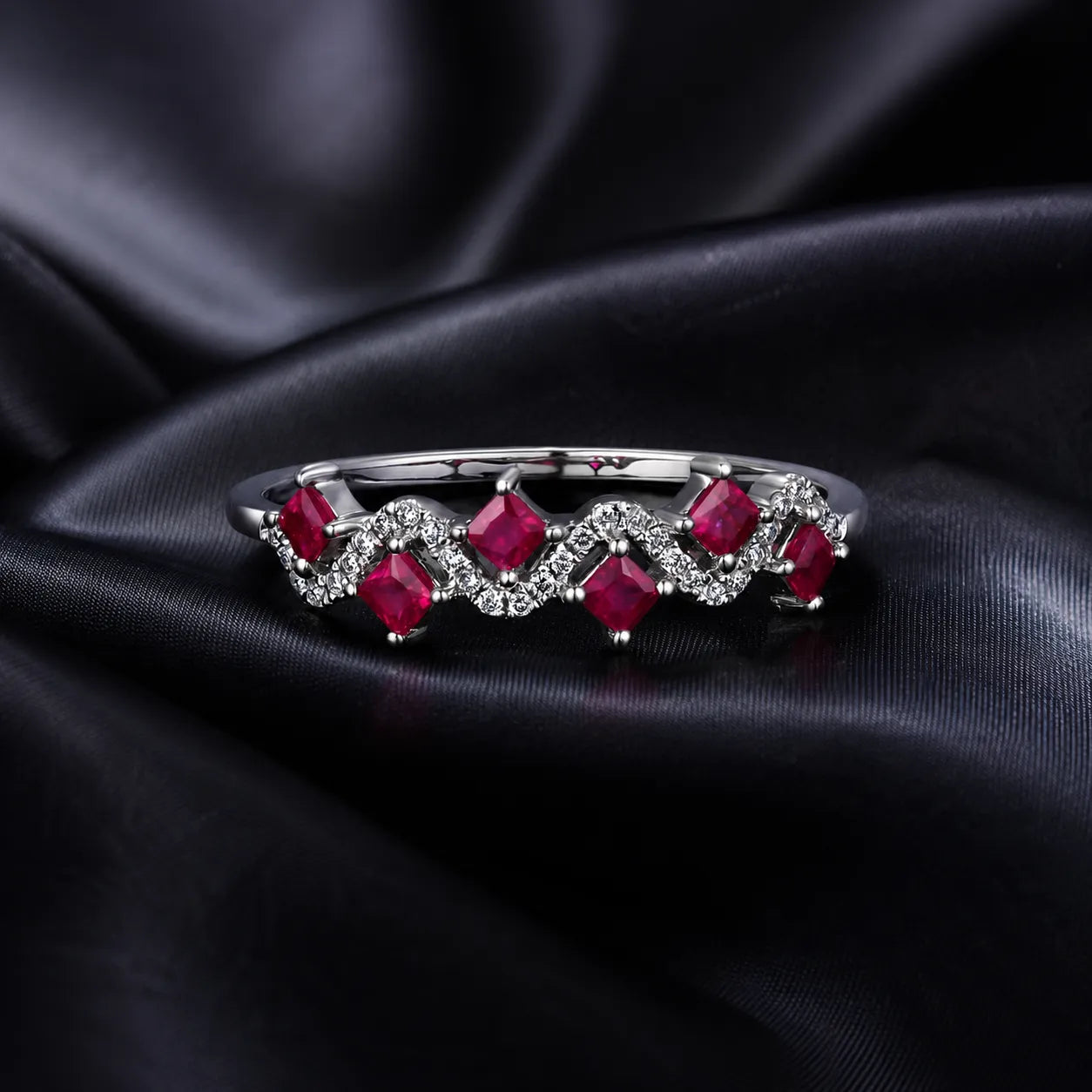 MUHUANG ruby and diamond wave ring displayed on black satin fabric