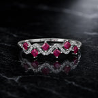 MUHUANG white gold ruby ring with diamond wave design on black marble background