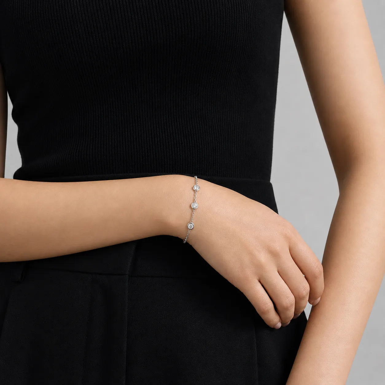 Minimalist diamond bracelet worn on wrist, styled with black outfit, showing elegant fit