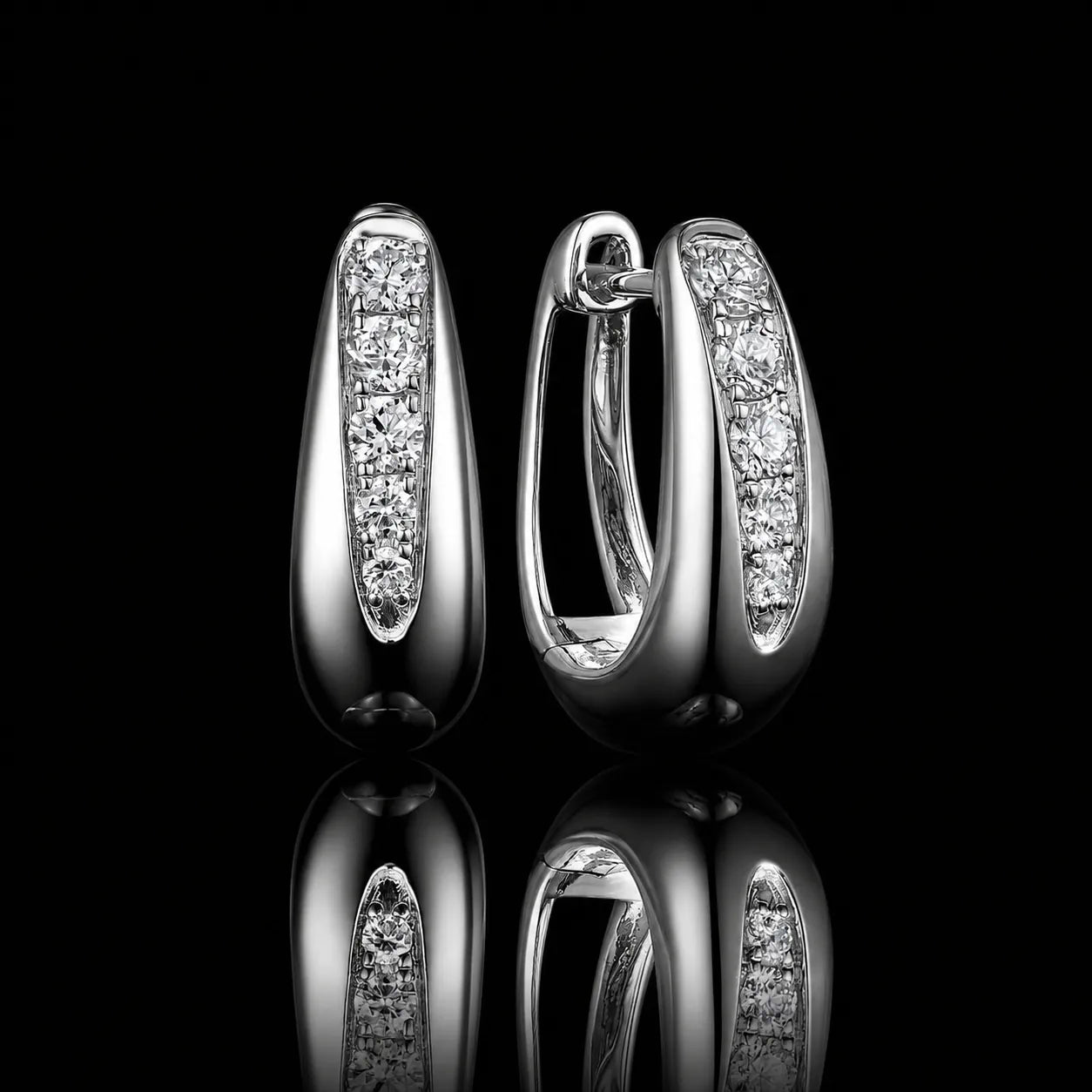 MUHUANG white gold diamond huggie hoop earrings on black reflective background
