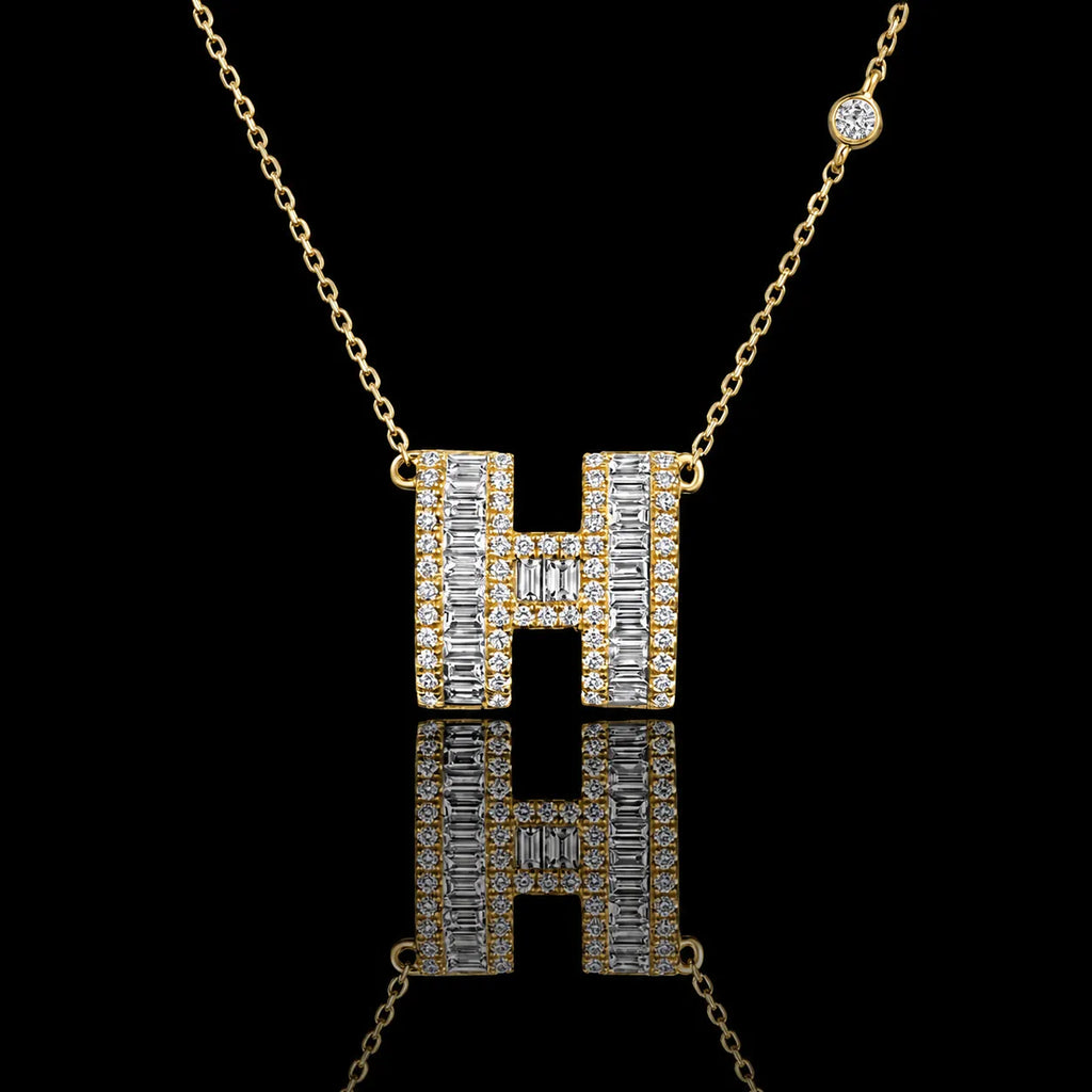 MUHUANG gold "H" pendant necklace with baguette and round diamonds, close-up on black background emphasizing sparkle and premium design.