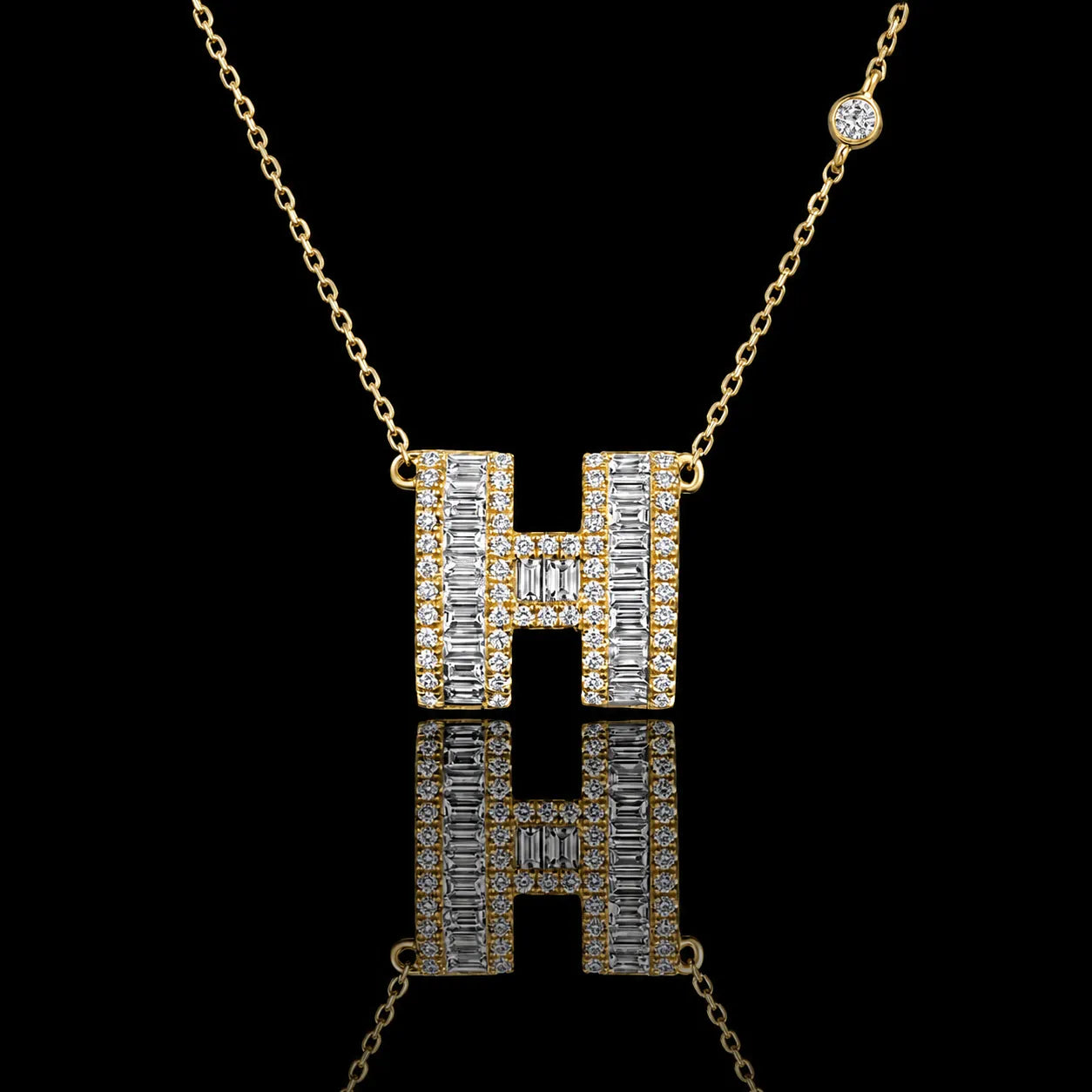 MUHUANG gold "H" pendant necklace with baguette and round diamonds, close-up on black background emphasizing sparkle and premium design.