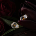 MUHUANG yellow gold diamond stud earrings styled with dark burgundy flowers