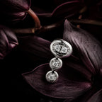 MUHUANG white gold diamond earrings displayed with dark orchid petals