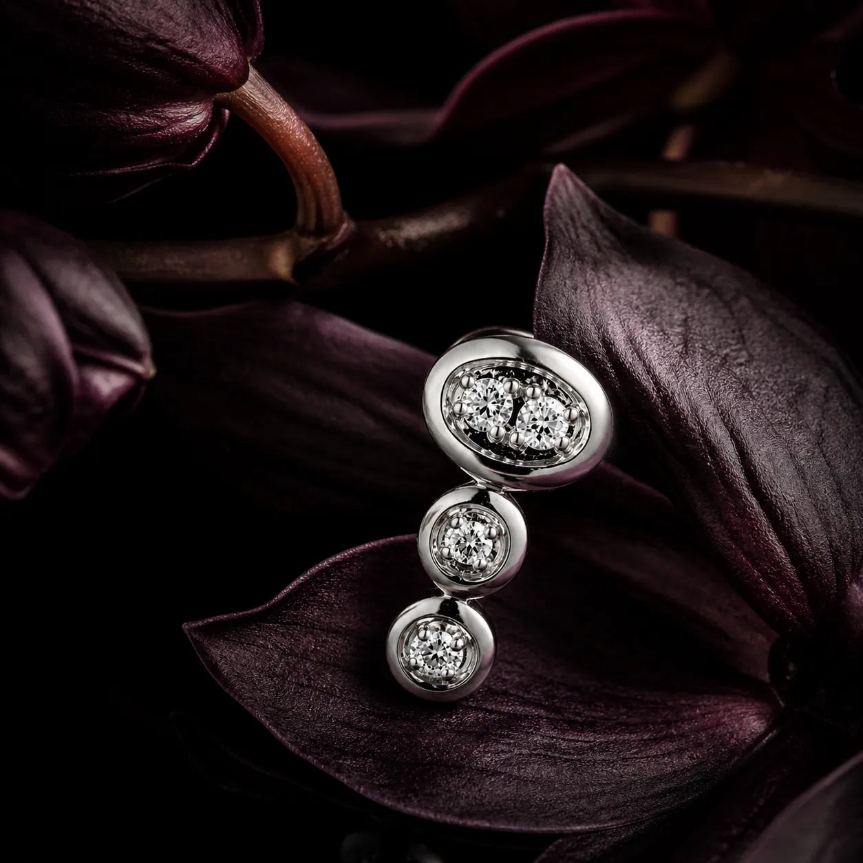 MUHUANG white gold diamond earrings displayed with dark orchid petals