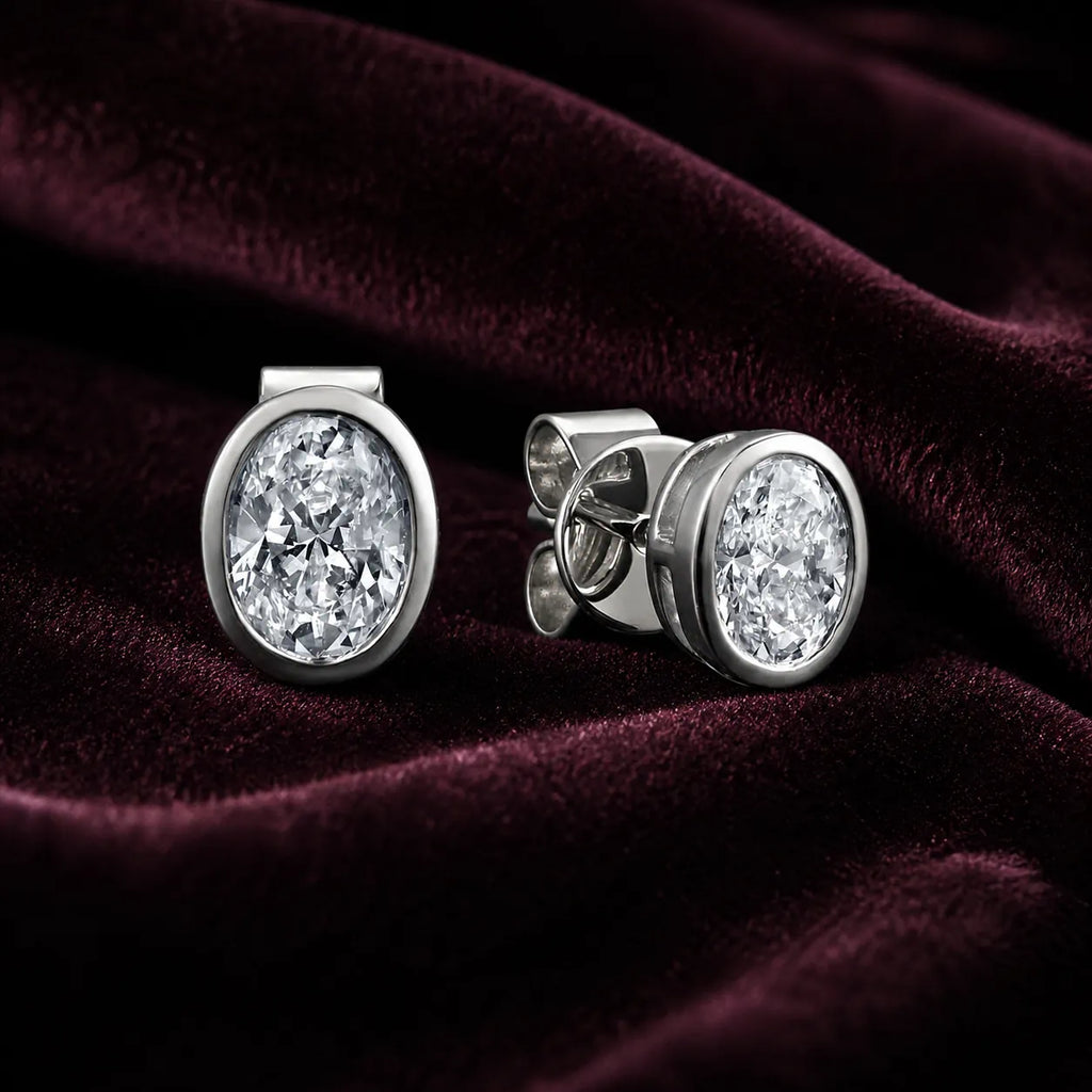 MUHUANG white gold oval diamond stud earrings on burgundy velvet