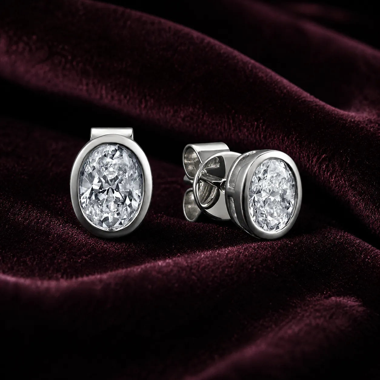 MUHUANG white gold oval diamond stud earrings on burgundy velvet