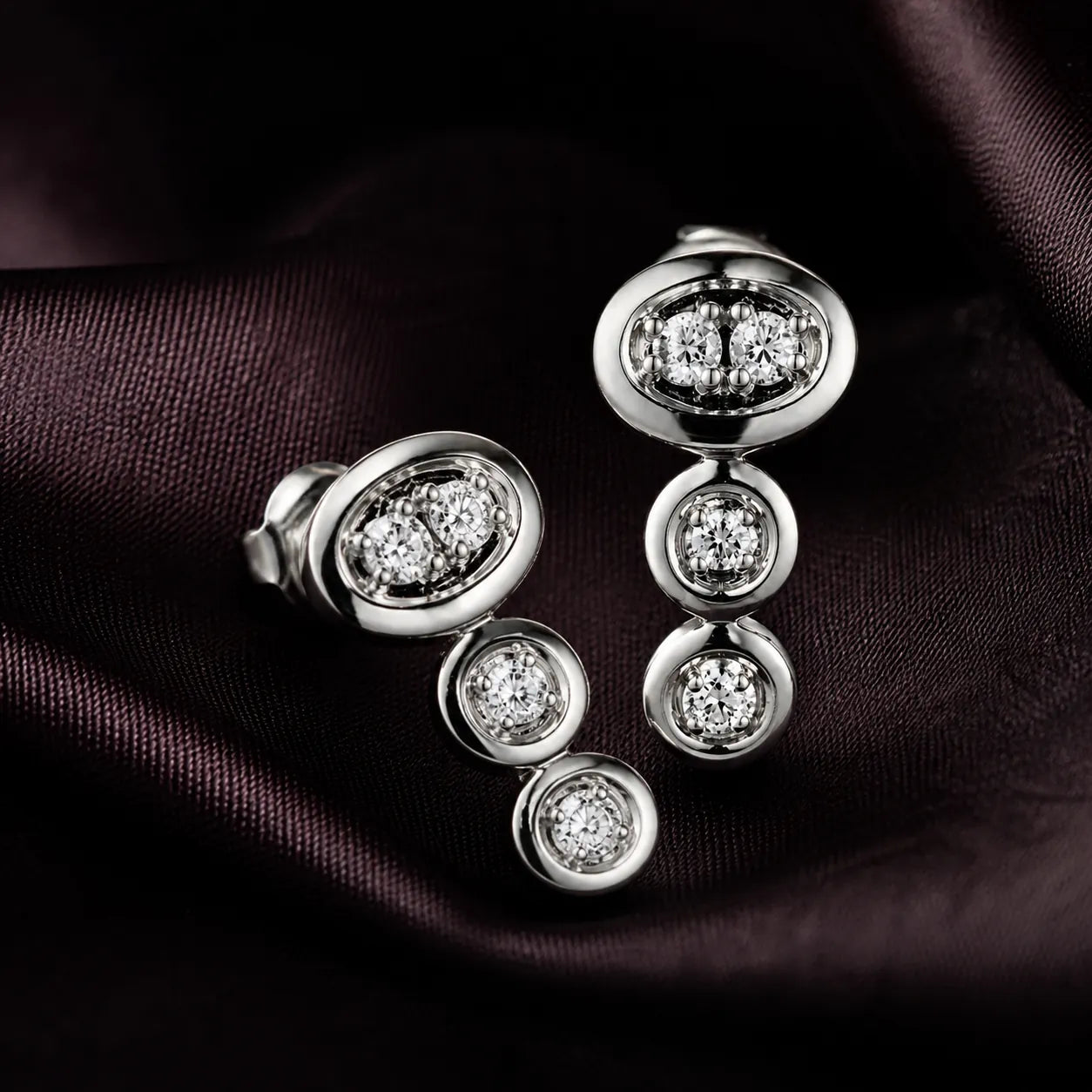 MUHUANG diamond drop earrings on dark satin fabric