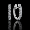 MUHUANG white gold baguette diamond hoop earrings on black reflective background