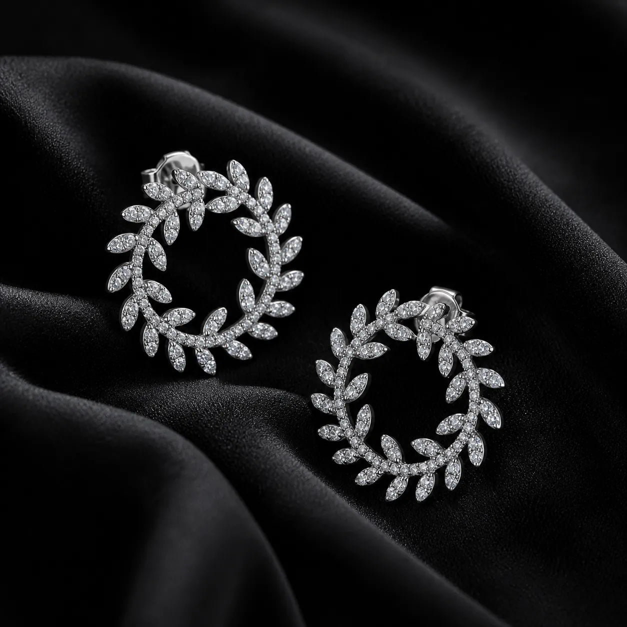 MUHUANG diamond laurel leaf hoop earrings on black satin fabric