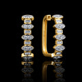 MUHUANG yellow gold baguette and round diamond hoop earrings on black reflective background