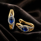 MUHUANG yellow gold sapphire hoop earrings on black satin fabric