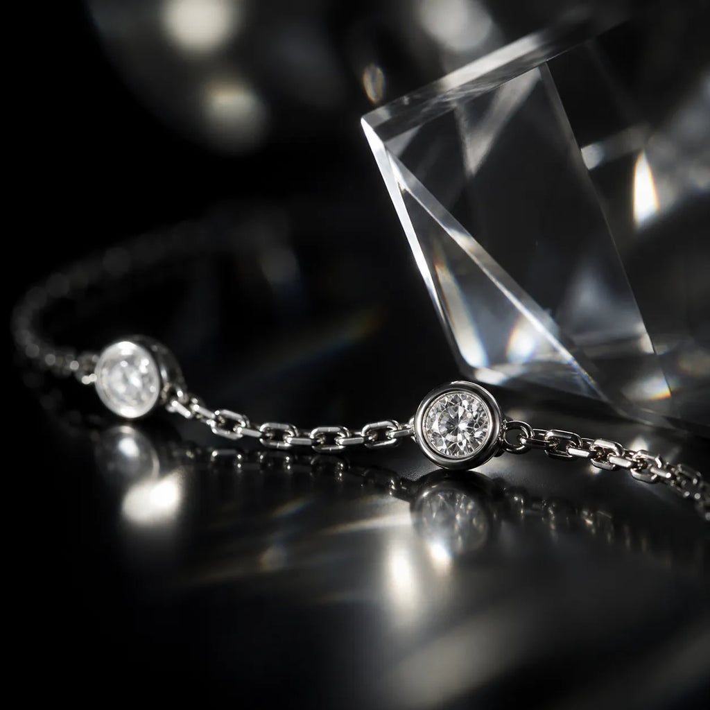 Bezel-set diamond bracelet reflecting light on black surface, emphasizing sparkle and craftsmanship