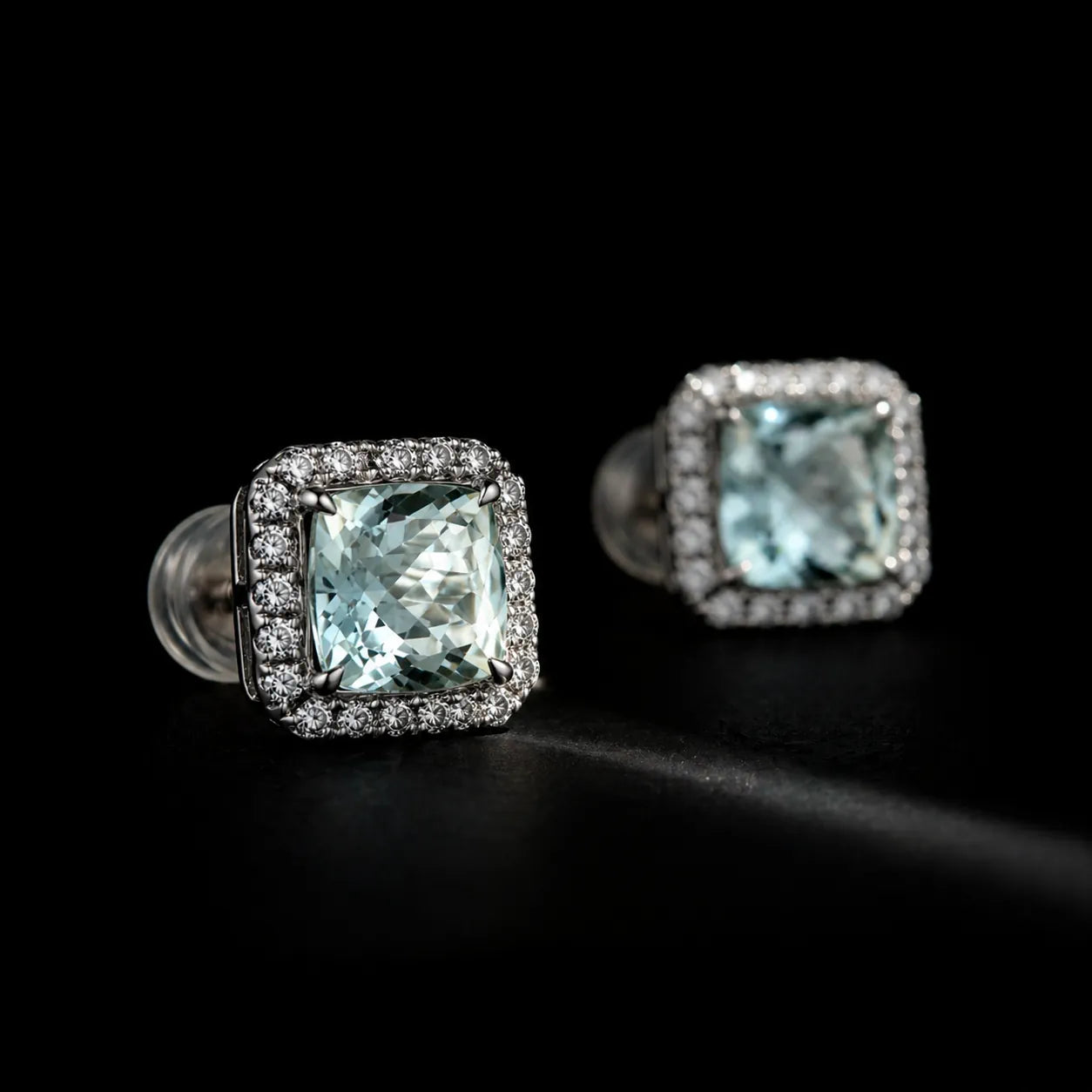 MUHUANG light blue gemstone stud earrings with diamond halo, close-up on dark background emphasizing luxury and fine detail.