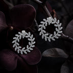 MUHUANG diamond laurel leaf earrings with dark floral background