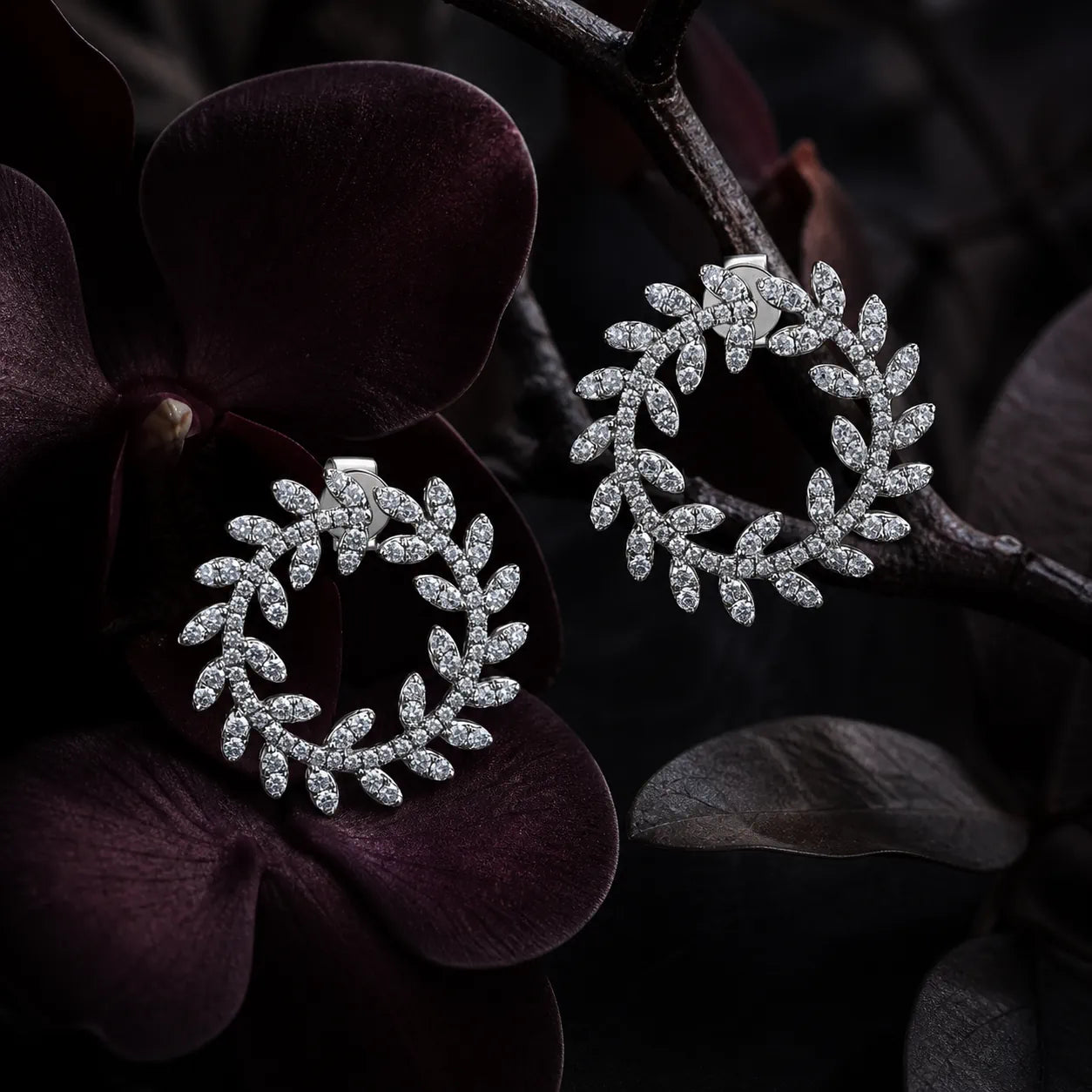 MUHUANG diamond laurel leaf earrings with dark floral background