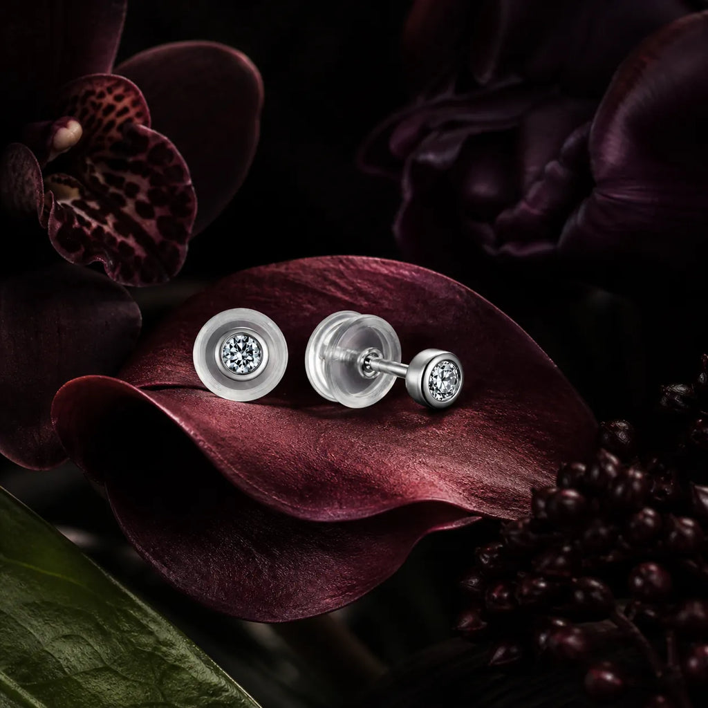 MUHUANG diamond stud earrings displayed on dark burgundy petals