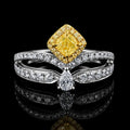 18K yellow and white gold yellow diamond ring, cushion-cut yellow center diamond with halo of white diamonds, on black reflective background